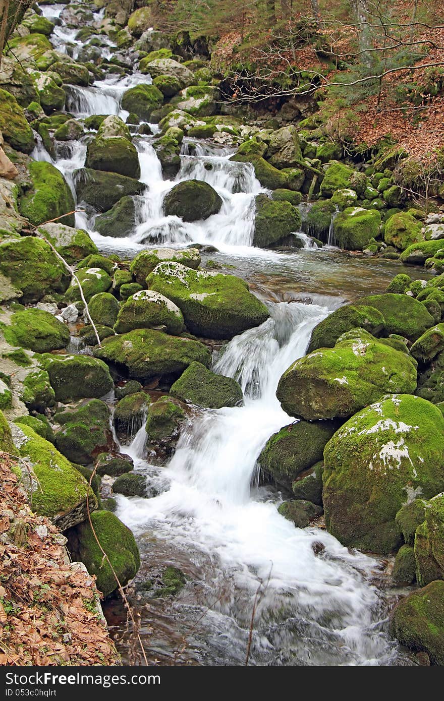 Stream in the forest, waterfalls and stones covered in green moss. Stream in the forest, waterfalls and stones covered in green moss