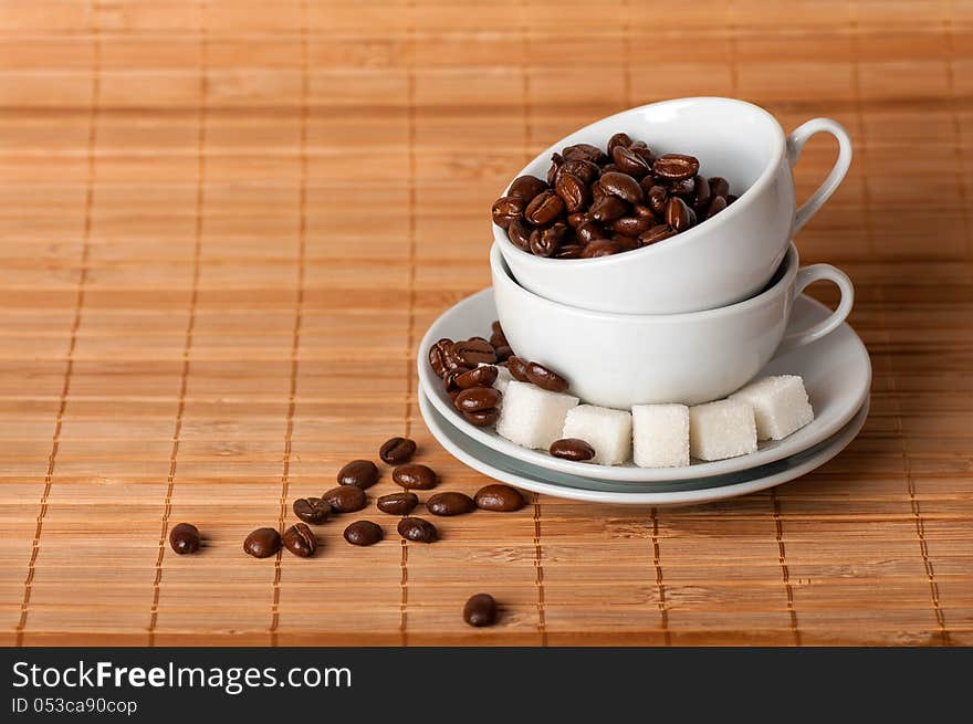 White Cups And Coffee Grains On A Saucer With Sugar