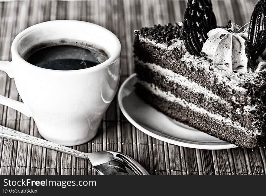 Black coffee, a slice of cake and a teaspoon