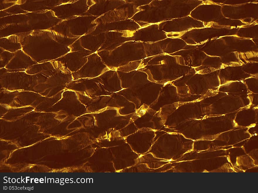 Background made ??ripples on the water golden yellow color. Background made ??ripples on the water golden yellow color