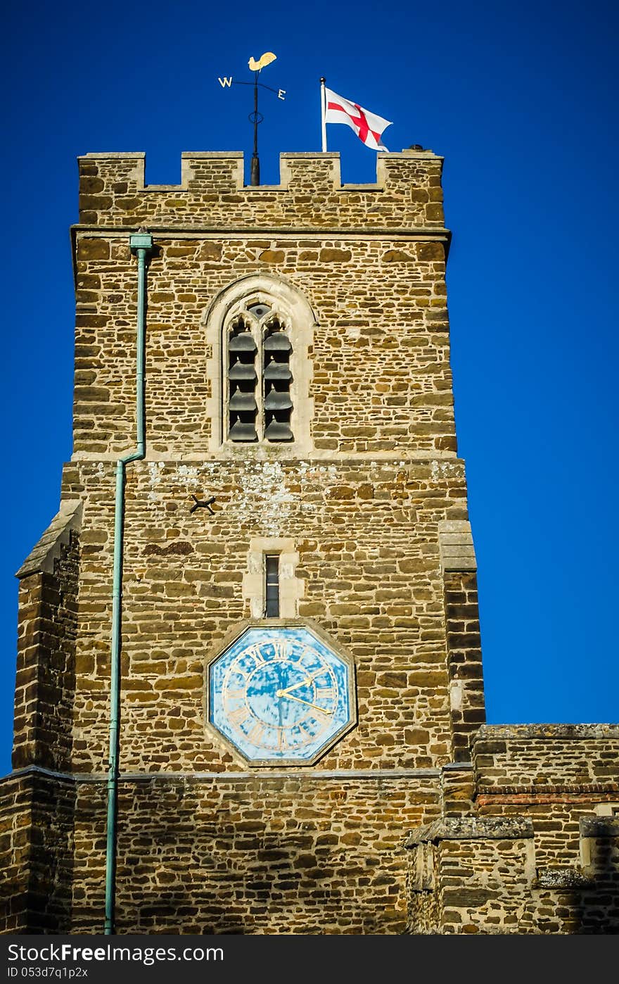 English church with St George Flag against blue sky