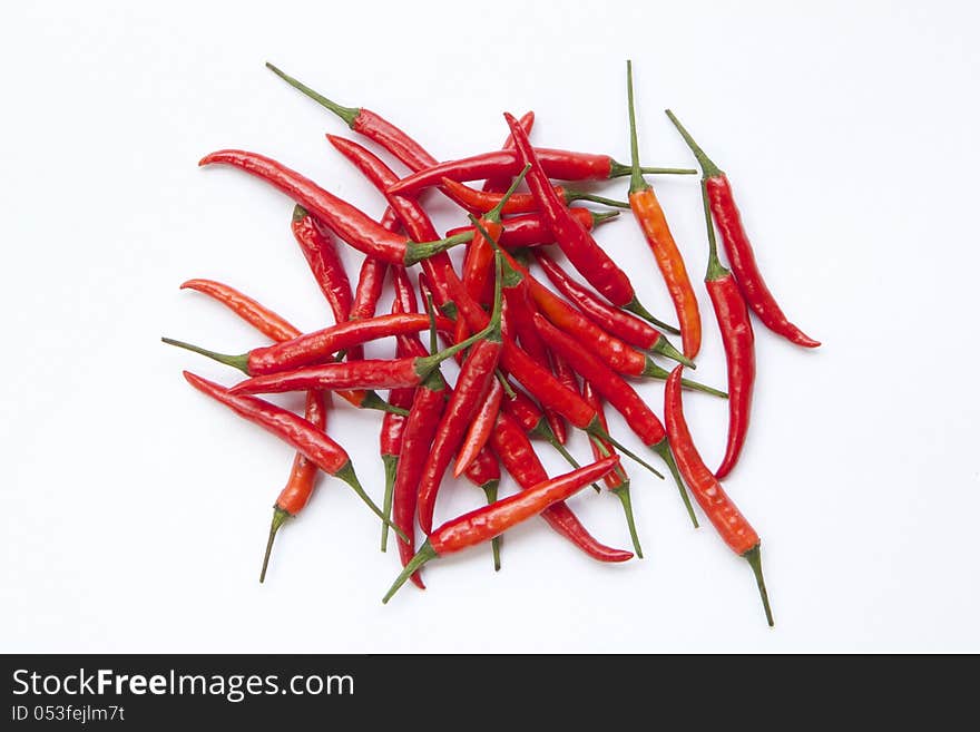 A pile of red chilli  on white background. A pile of red chilli  on white background.