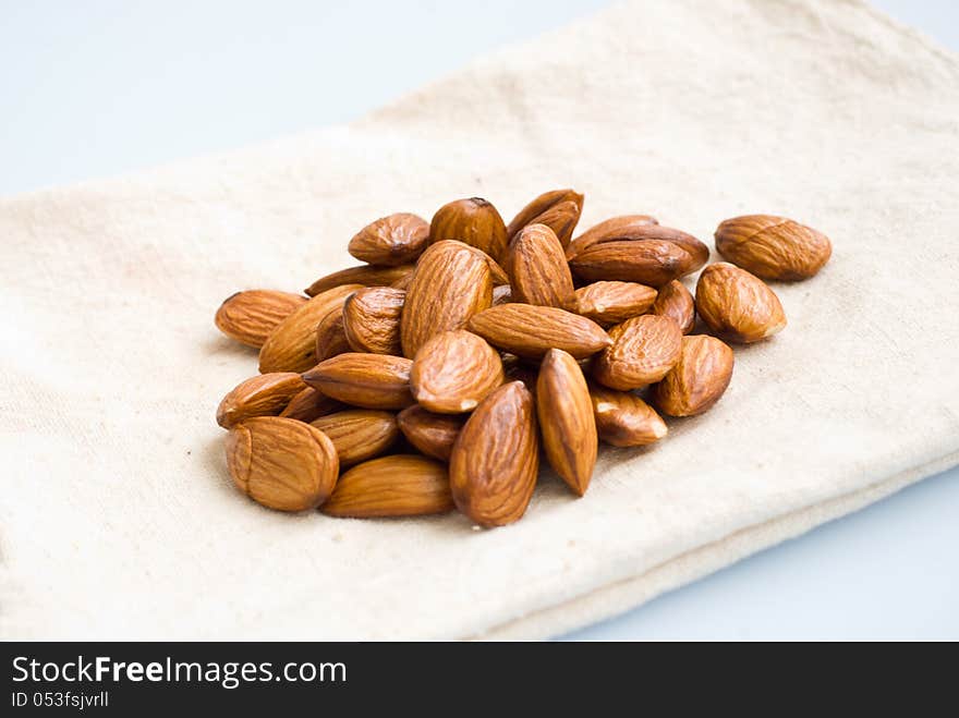 A pile of almonds on off-white bag