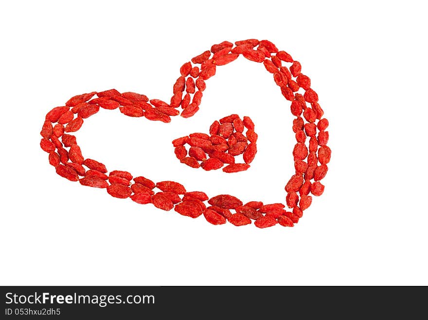 Goji berries heart shaped on white