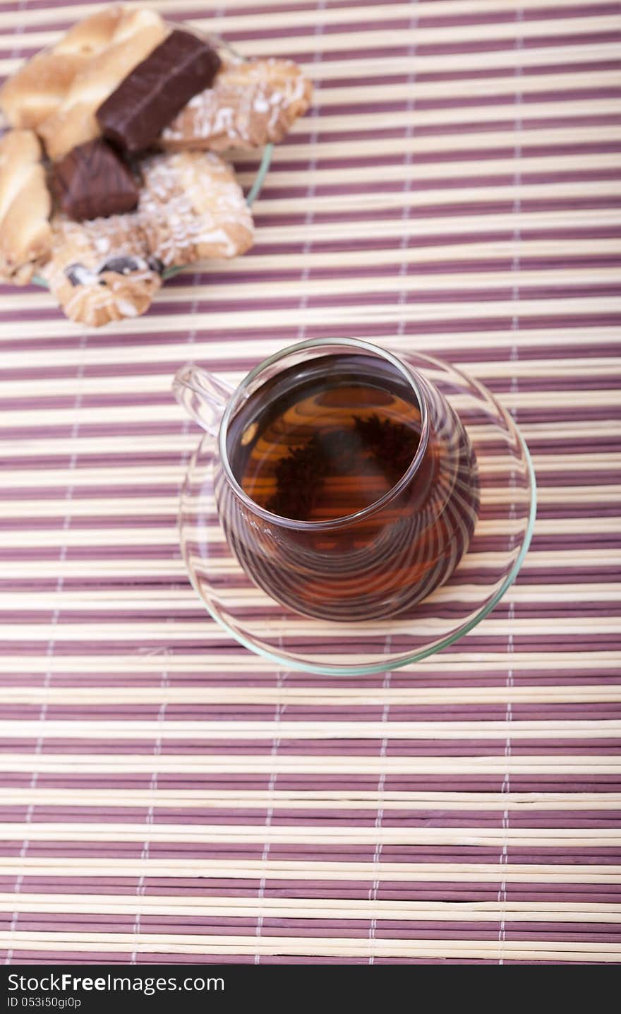 A cup of tea with a plate with cookies