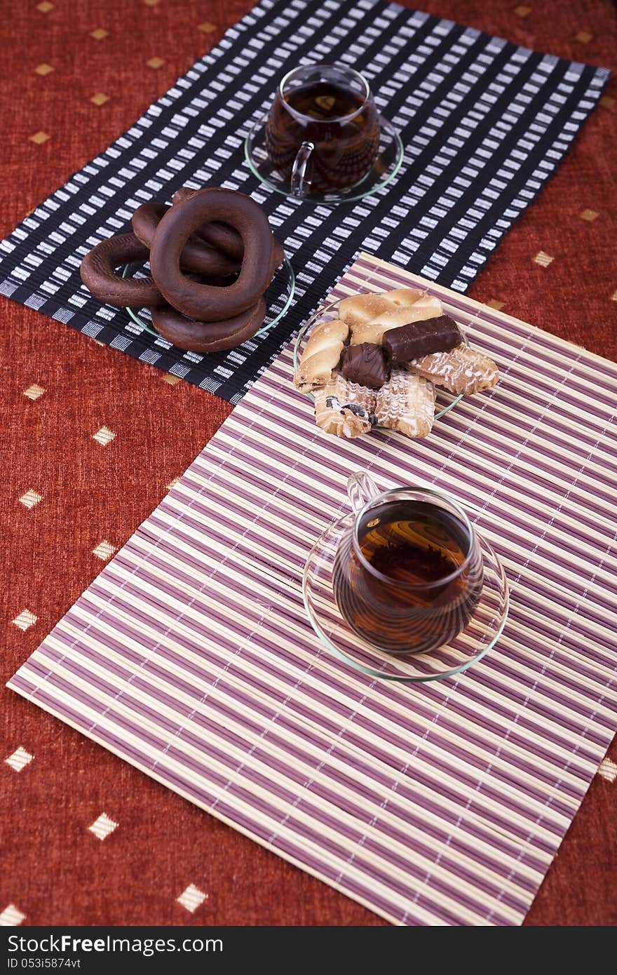 Two cups of tea with two plates with cookies