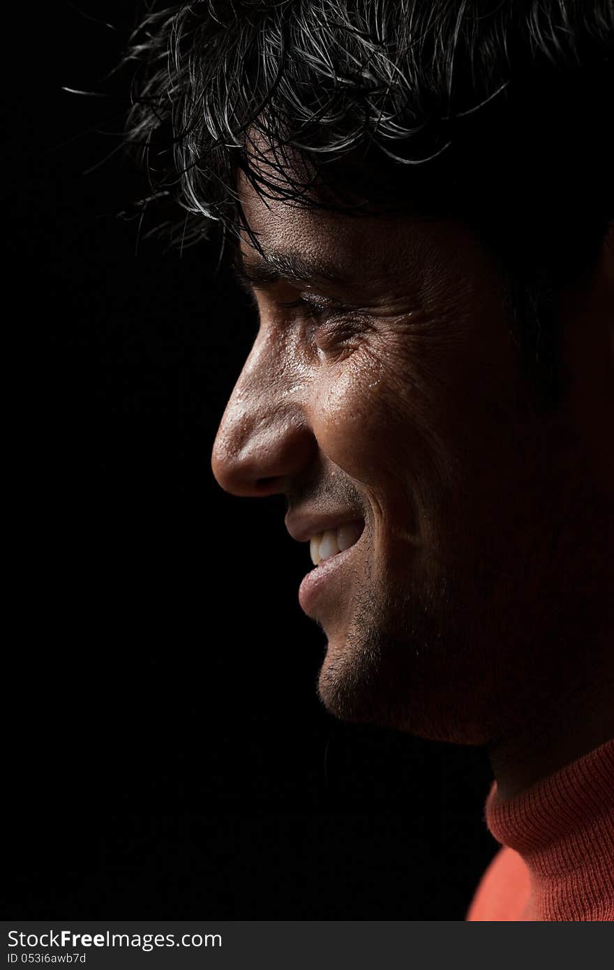 Grains & textures are added in the portrait of Indian man smiling over dark background. Grains & textures are added in the portrait of Indian man smiling over dark background