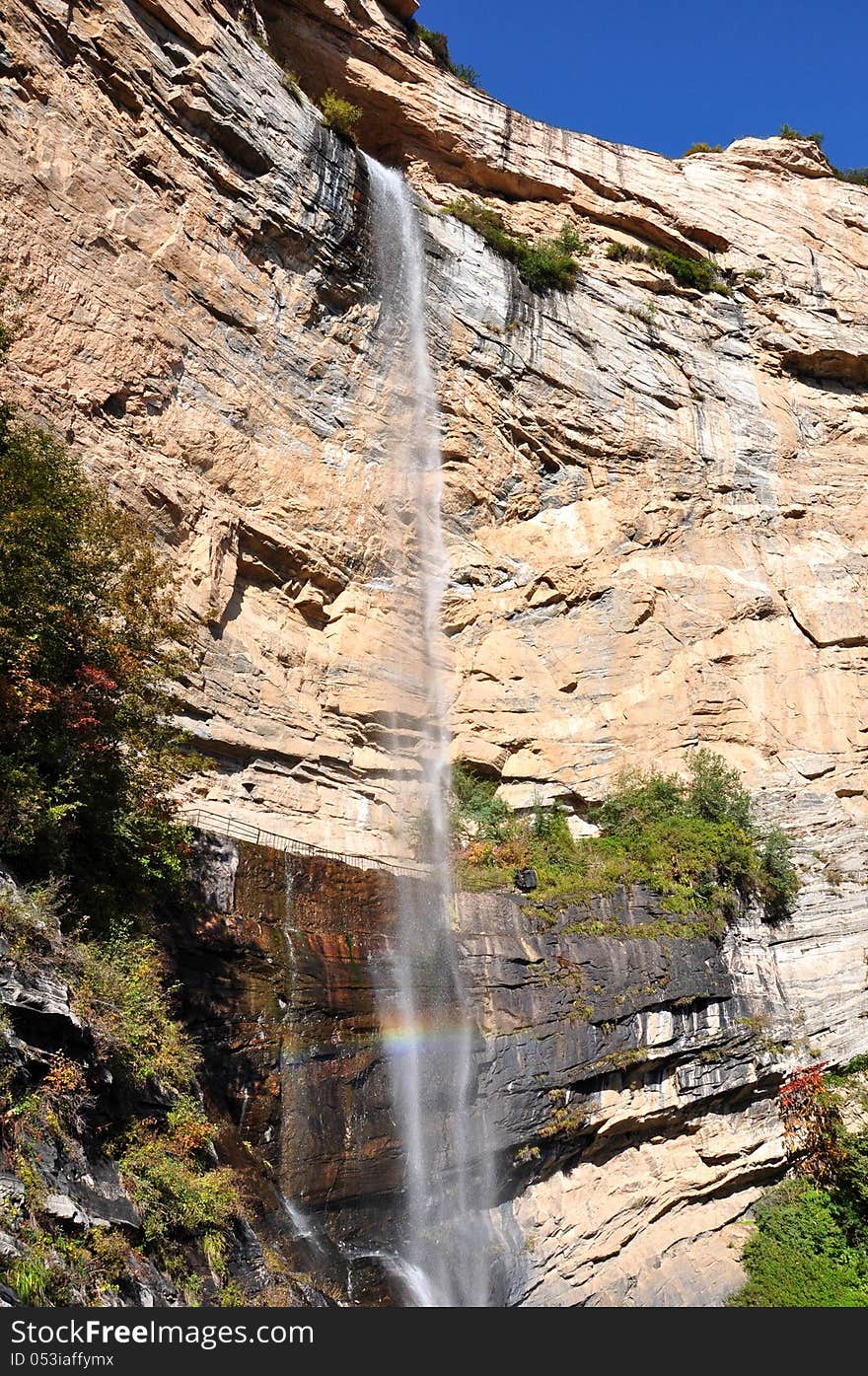 Falling waterfall with sun intertwined, and launched into a rainbow