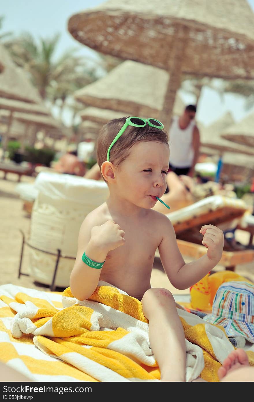 After bathing cheerful child sitting under a canopy in the towel. After bathing cheerful child sitting under a canopy in the towel