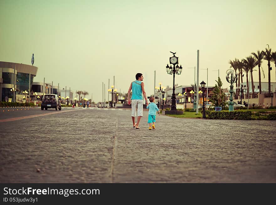 On narrow street against a decline the father with the son walks. On narrow street against a decline the father with the son walks