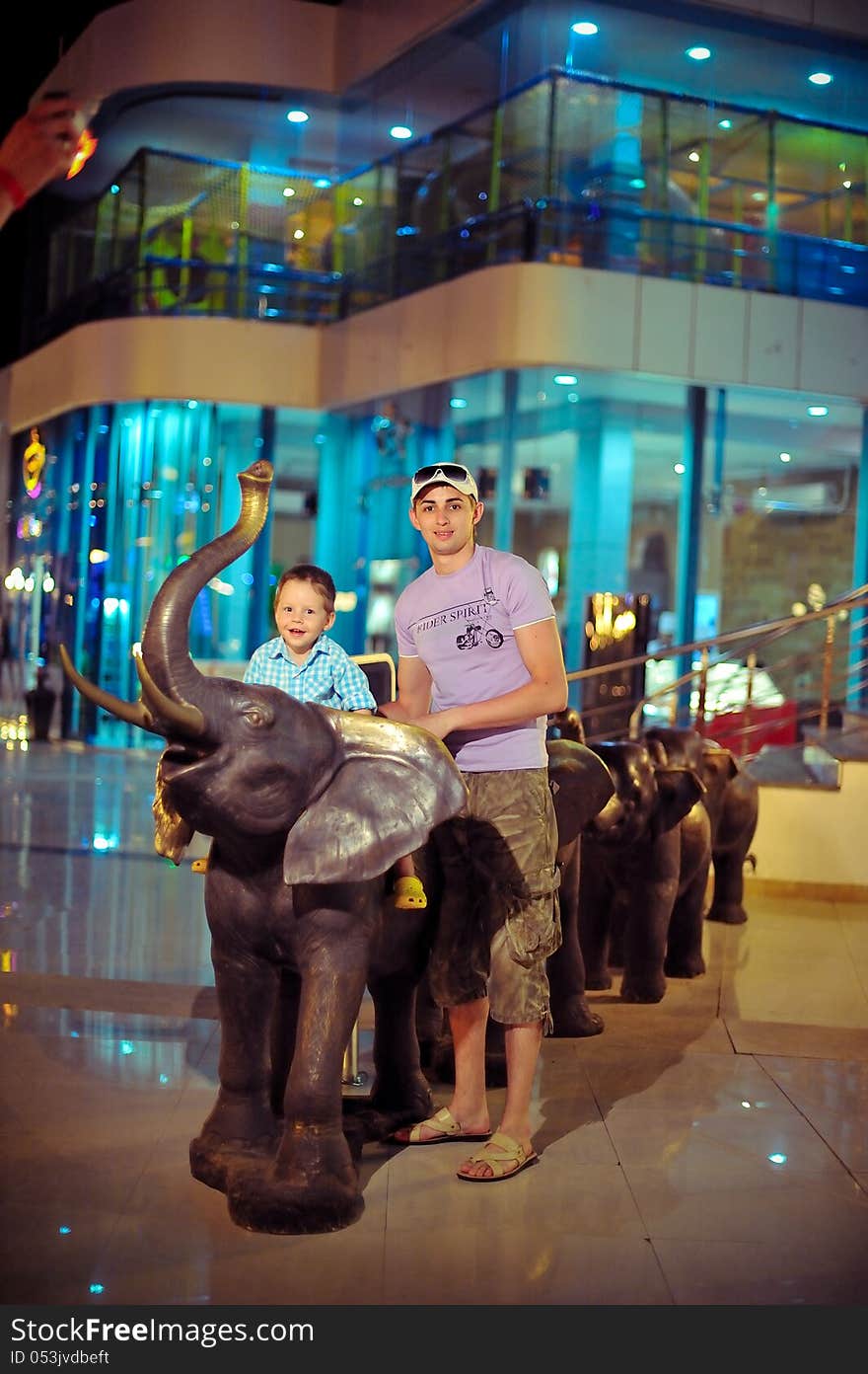 In the evening on the street boys playing with an elephant sculpture. In the evening on the street boys playing with an elephant sculpture