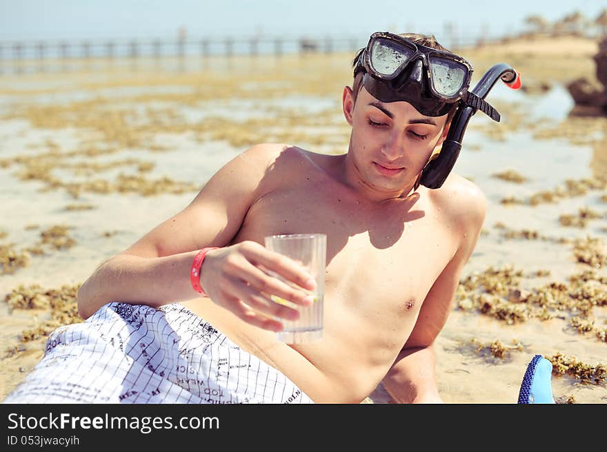 On the bank of a diver in a black mask and tube surfaced and quenches. On the bank of a diver in a black mask and tube surfaced and quenches