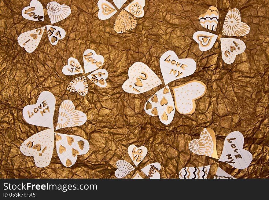 Handmade hearts on a background of golden-brown textured paper. Handmade hearts on a background of golden-brown textured paper