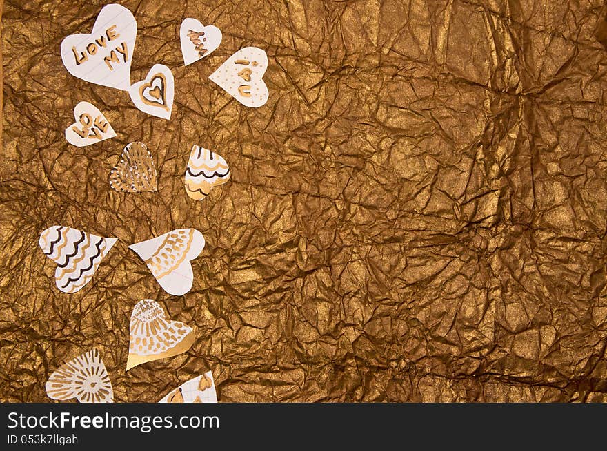 Handmade hearts on a background of golden-brown textured paper. Handmade hearts on a background of golden-brown textured paper