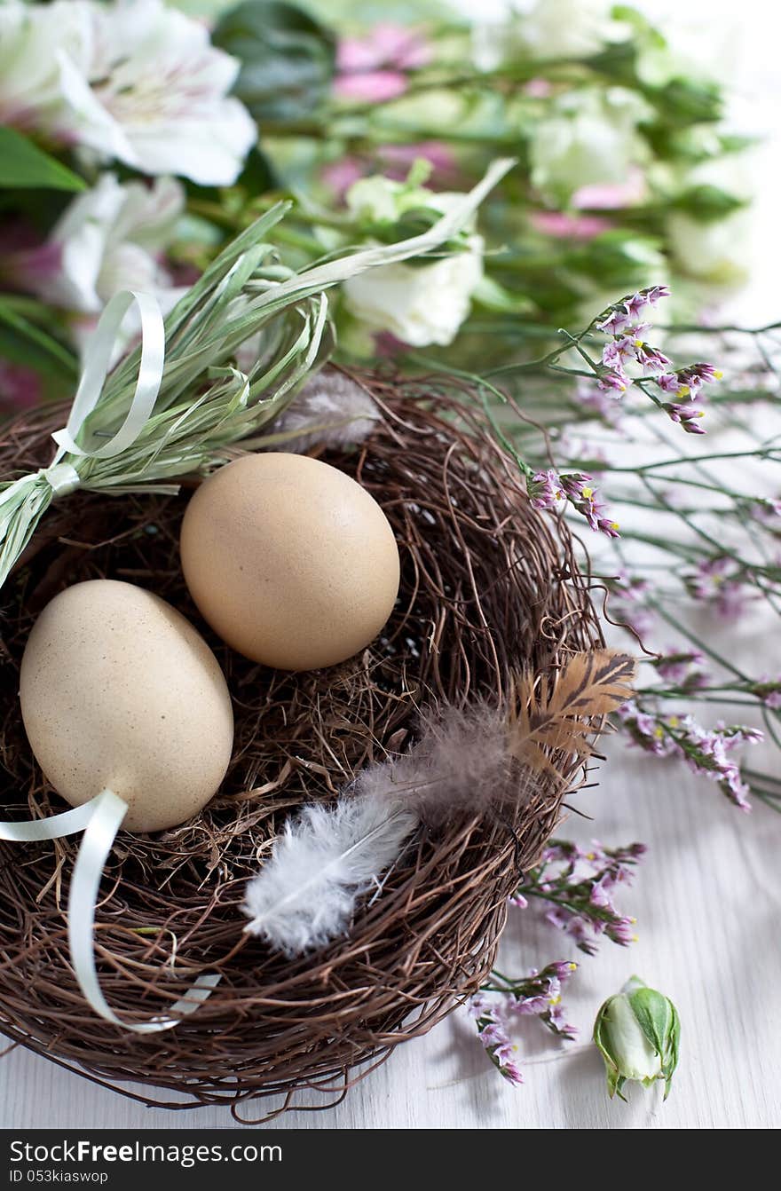 Easter basket with easter eggs and flowers on wooden background