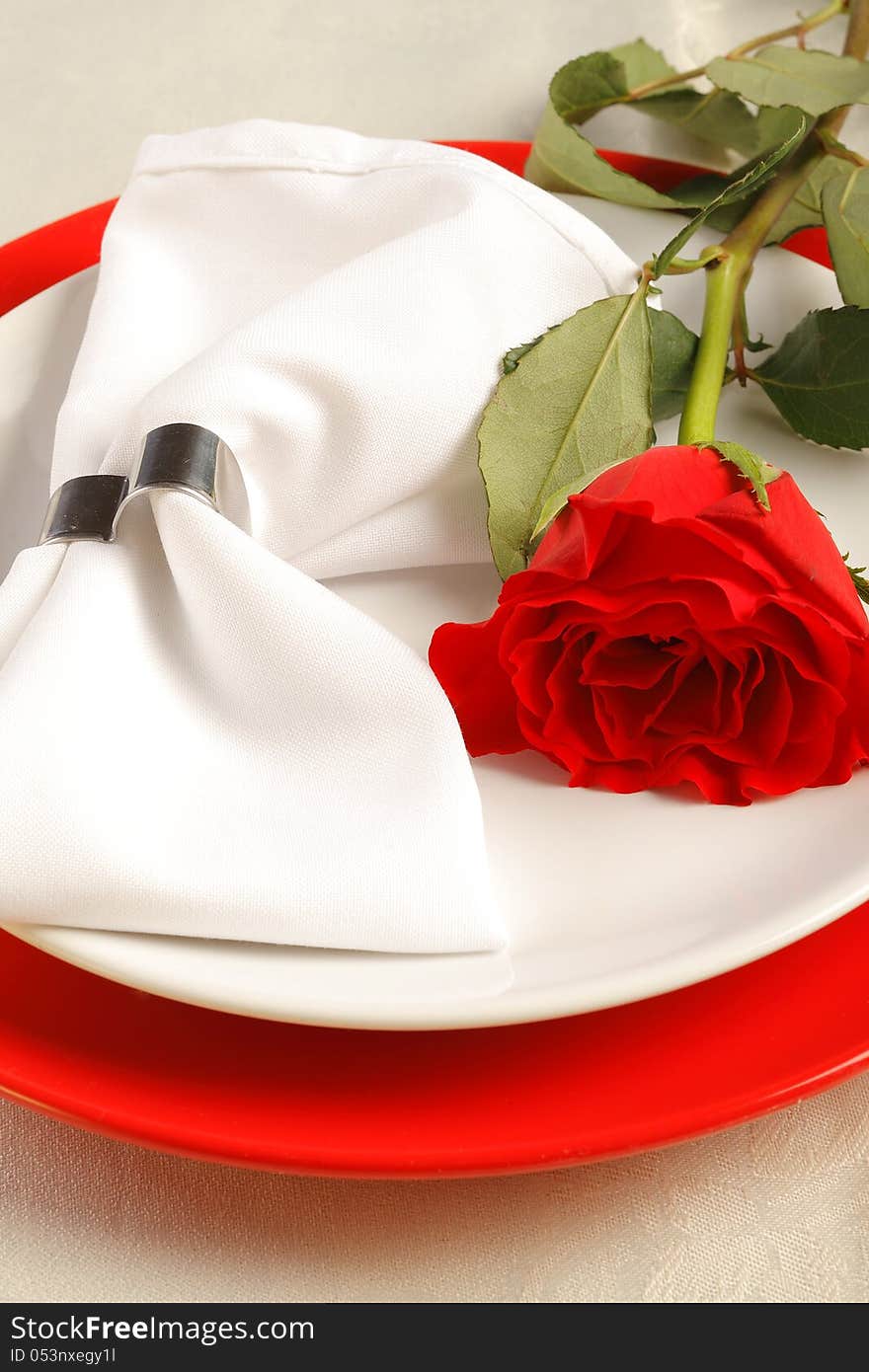 Romantic dinner setting with a red rose on white napkin. Romantic dinner setting with a red rose on white napkin