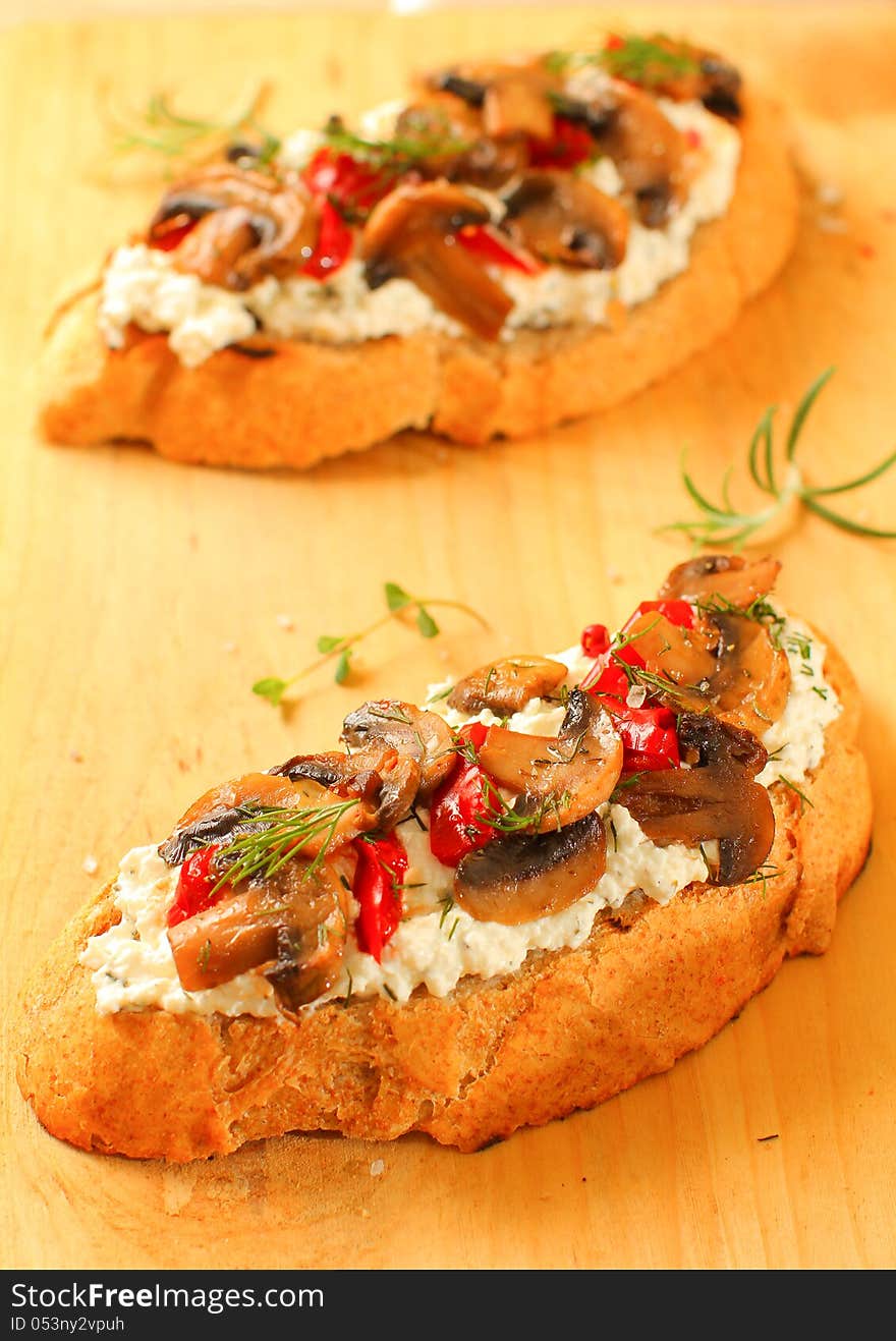 Appetizer with roasted mushrooms, red peppers and cream cheese on rustic bread. Appetizer with roasted mushrooms, red peppers and cream cheese on rustic bread