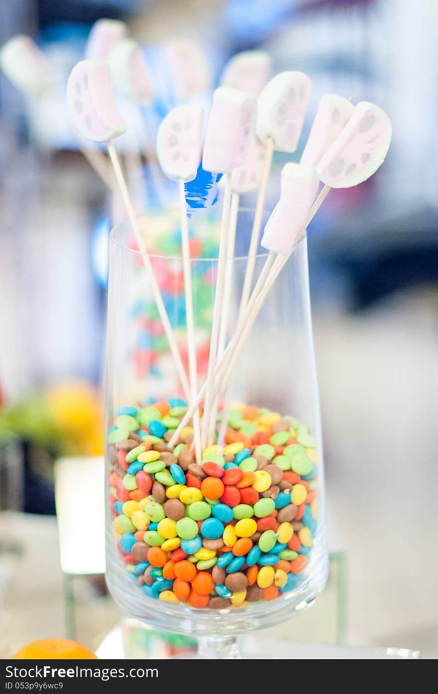 Delicious colored candies in a glass and lollipops for an event candy bar. Delicious colored candies in a glass and lollipops for an event candy bar