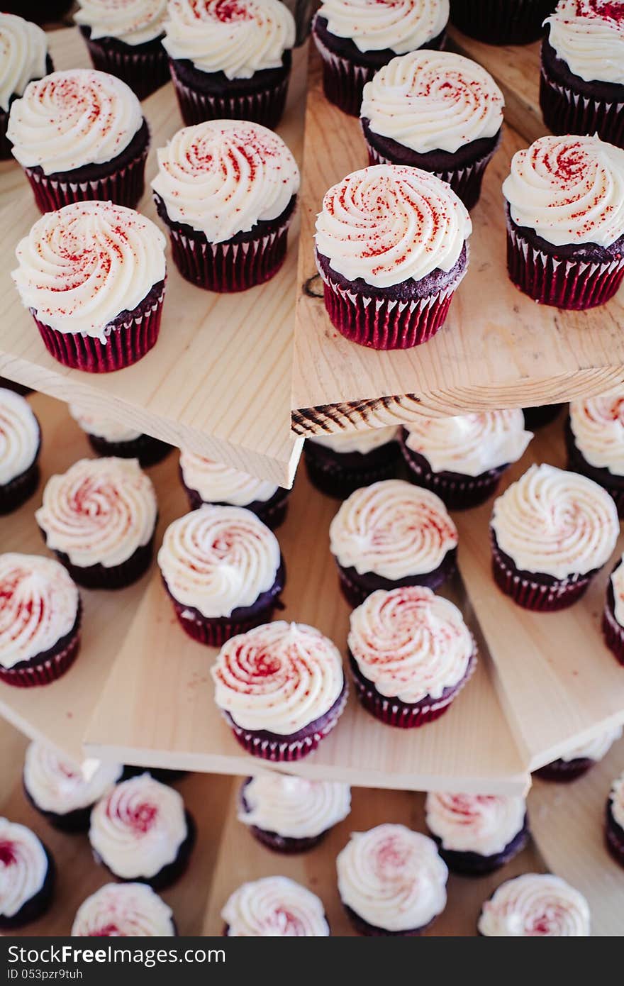 Delicious red velvet cupcakes on a wooden cake stand