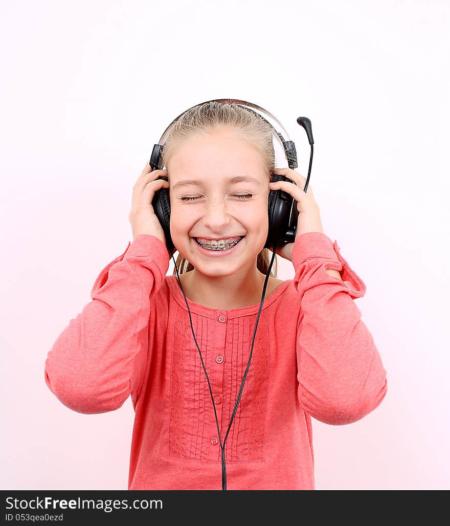 Blond girl listens to music with headphones and laughs