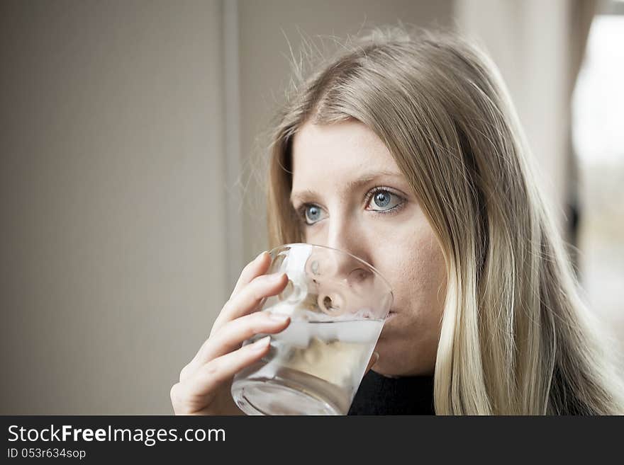 Pretty young blonde woman drinking a glass of water. Pretty young blonde woman drinking a glass of water.