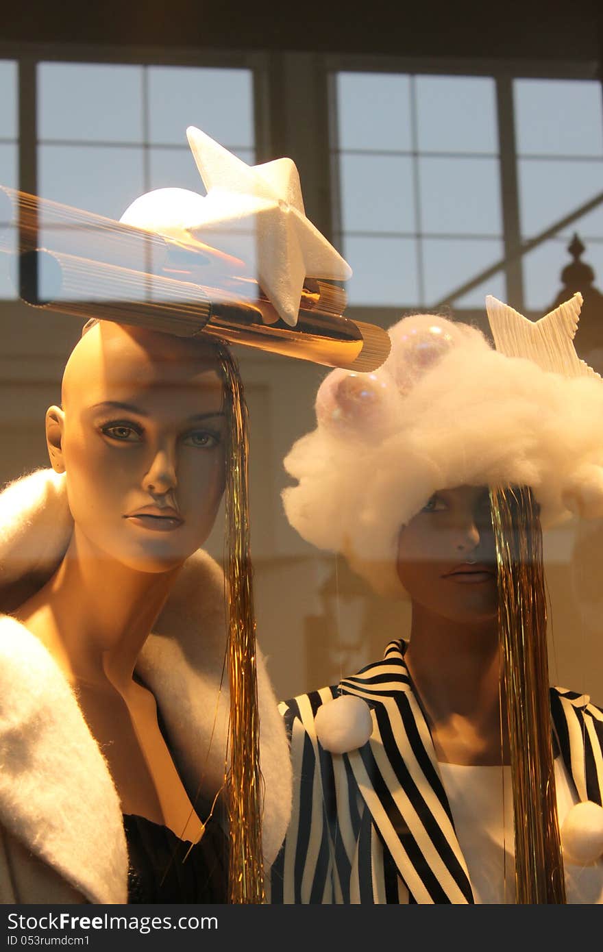 Christmas fashion shown by two models placed in the window and reflex in glass. Christmas fashion shown by two models placed in the window and reflex in glass