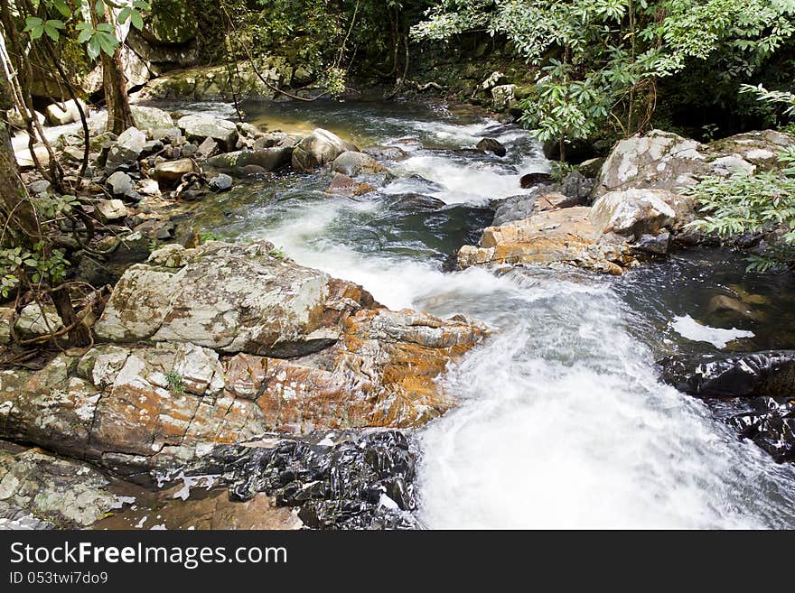 The flowing of waterfall  on big rock that be full of moss