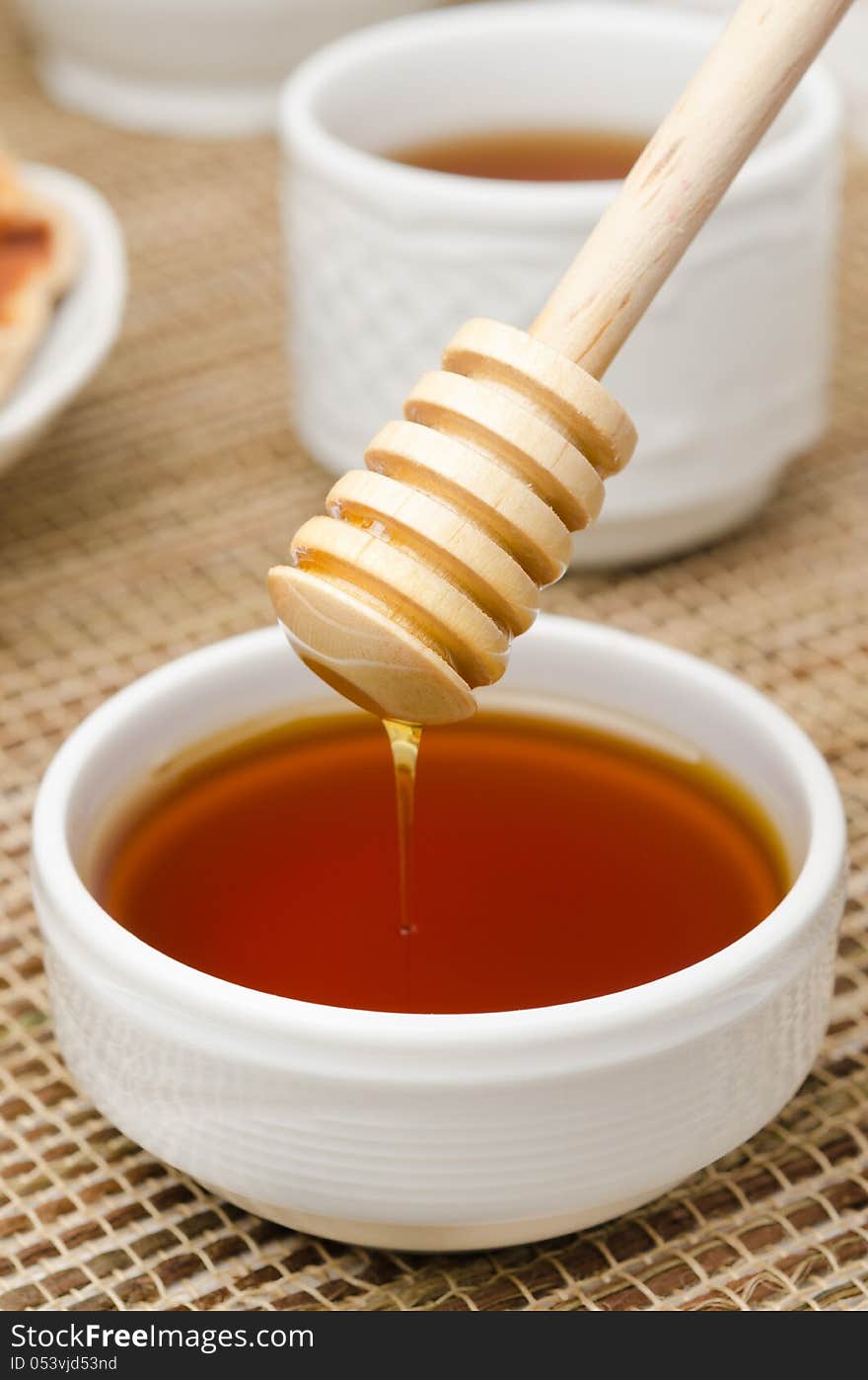 Bowl Of Honey With Wooden Dipper Closeup