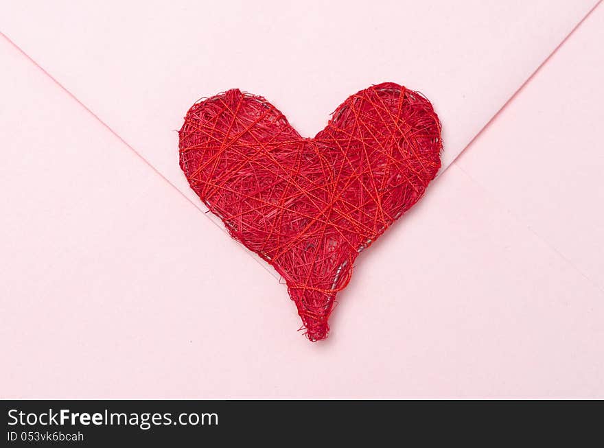 Red heart on a pink envelope closeup