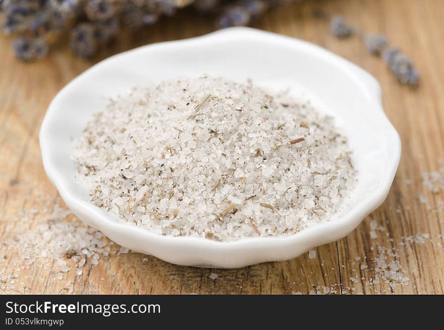 Sea ​​salt with lavender in a white bowl closeup horizontal. Sea ​​salt with lavender in a white bowl closeup horizontal