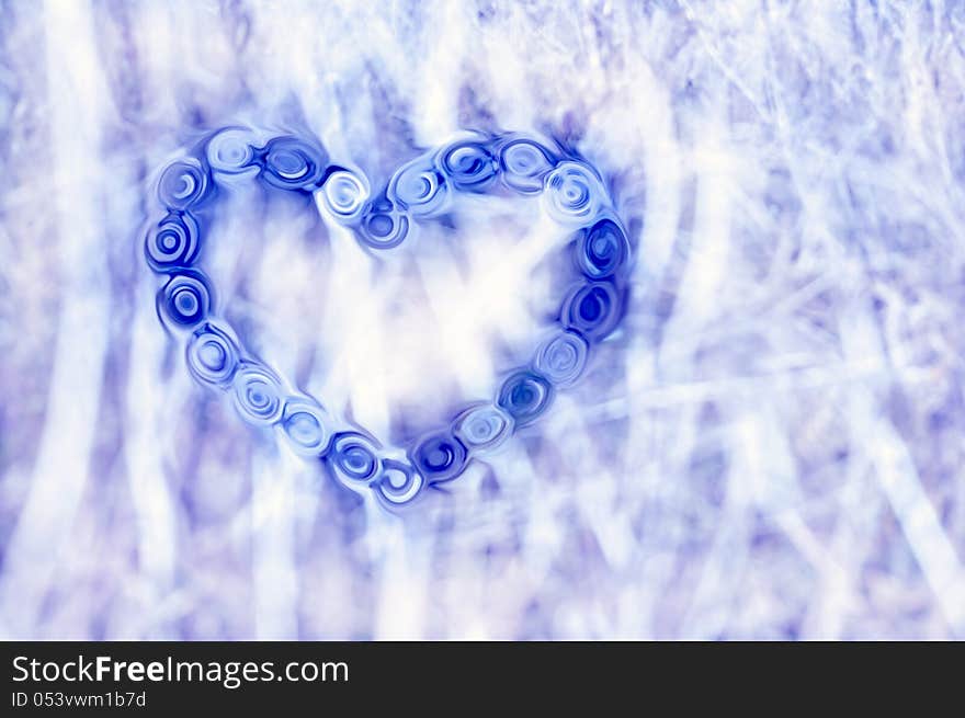 One blue heart consisting of liquified details on a light dappled background. One blue heart consisting of liquified details on a light dappled background