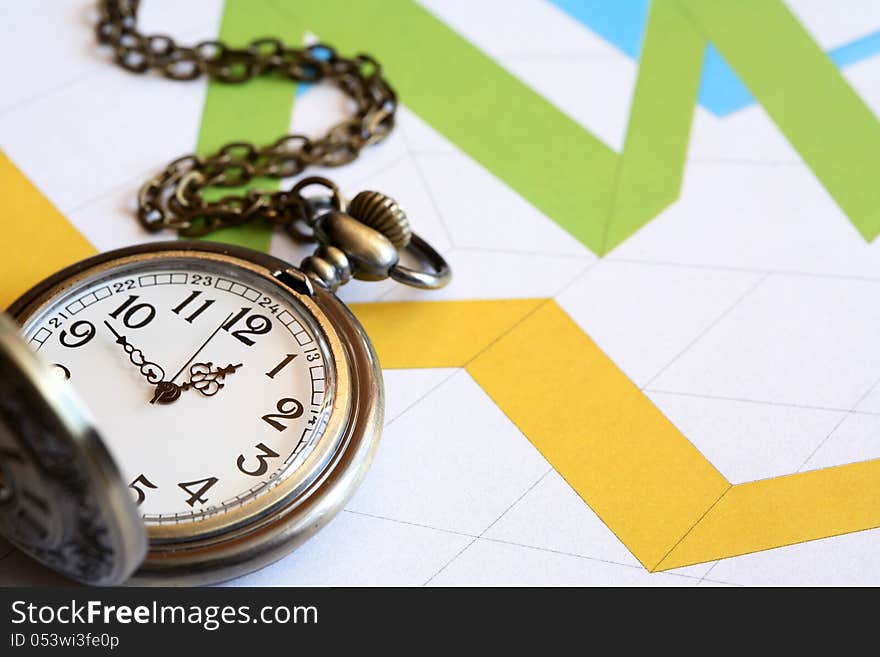 Business concept. Pocket watch on paper background with color chart. Business concept. Pocket watch on paper background with color chart