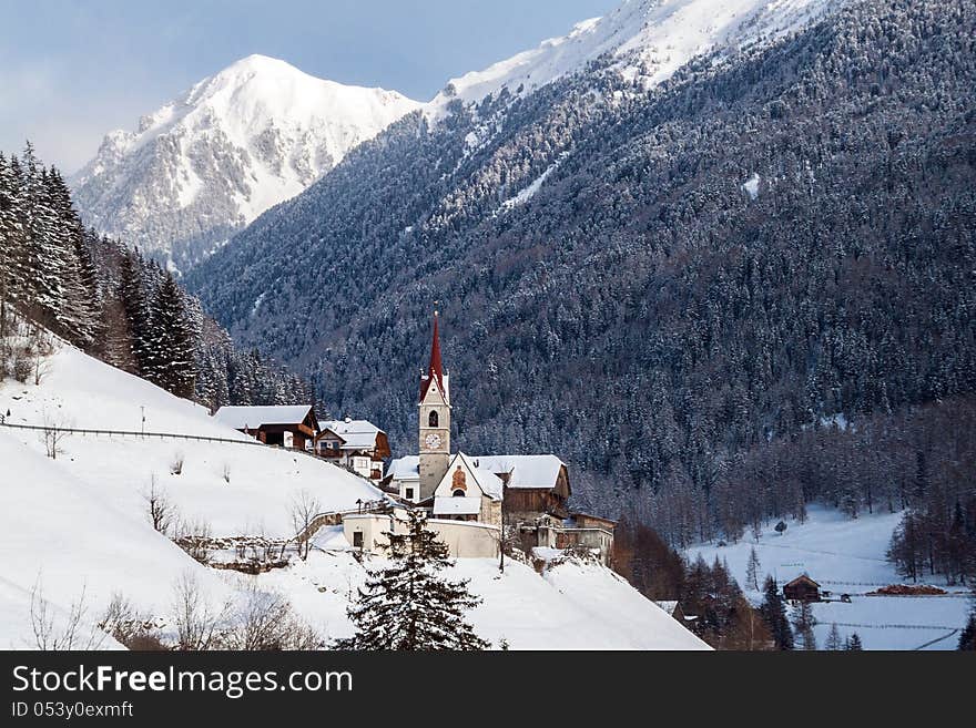 A wintertime view of a small church with a tall steeple