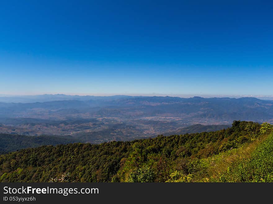 Mountain range and town in valley with blue sky, northern Thailand. Mountain range and town in valley with blue sky, northern Thailand