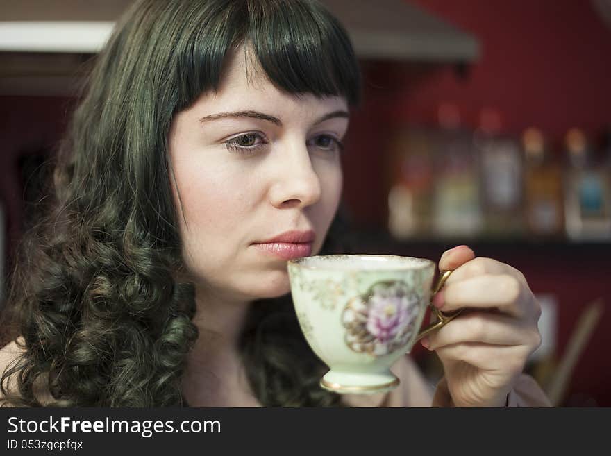 Portrait of a young woman with antique tea cup and saucer.