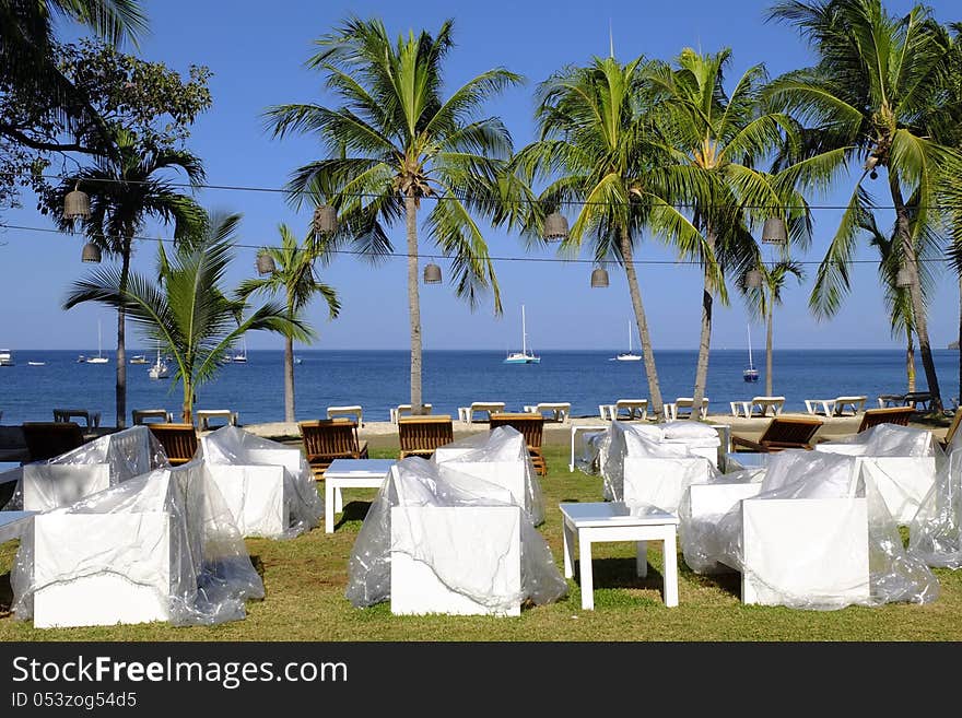 White chairs under transparent protection platic early in the morning with view on the Pacific ocean in Bahia Coco in Costa Rica. White chairs under transparent protection platic early in the morning with view on the Pacific ocean in Bahia Coco in Costa Rica