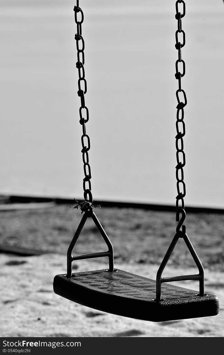 Set of empty swings in sand