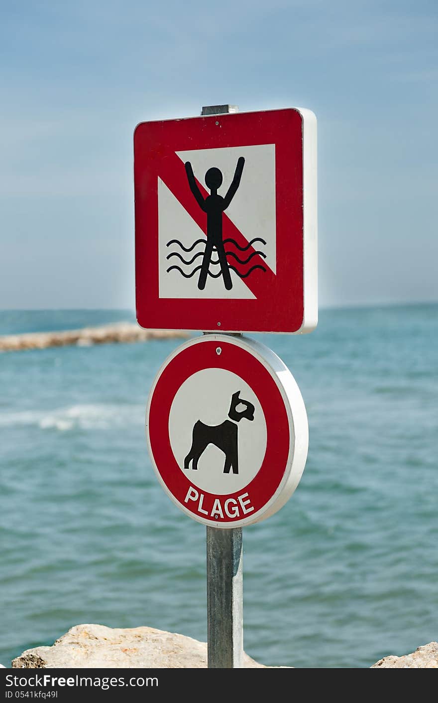 Signs prohibiting swimming and dog walking on the sea background. Signs prohibiting swimming and dog walking on the sea background