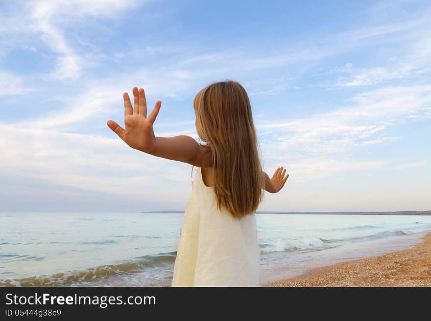 Small girl  day at sunny beach looking to the sea