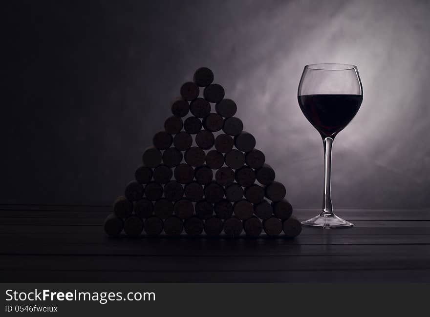 Glass with red wine near wine jams on a black background