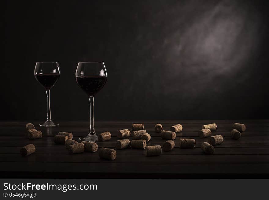 Two glasses of wine on a table with jams on a black background