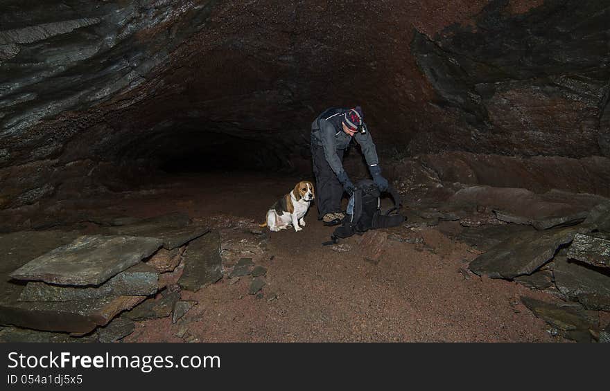 A man and a dog in a cave.