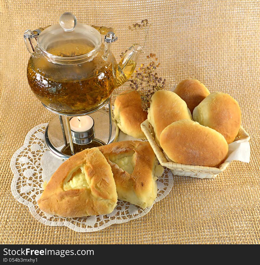 Teapot with stuffed buns and burning candle. Teapot with stuffed buns and burning candle