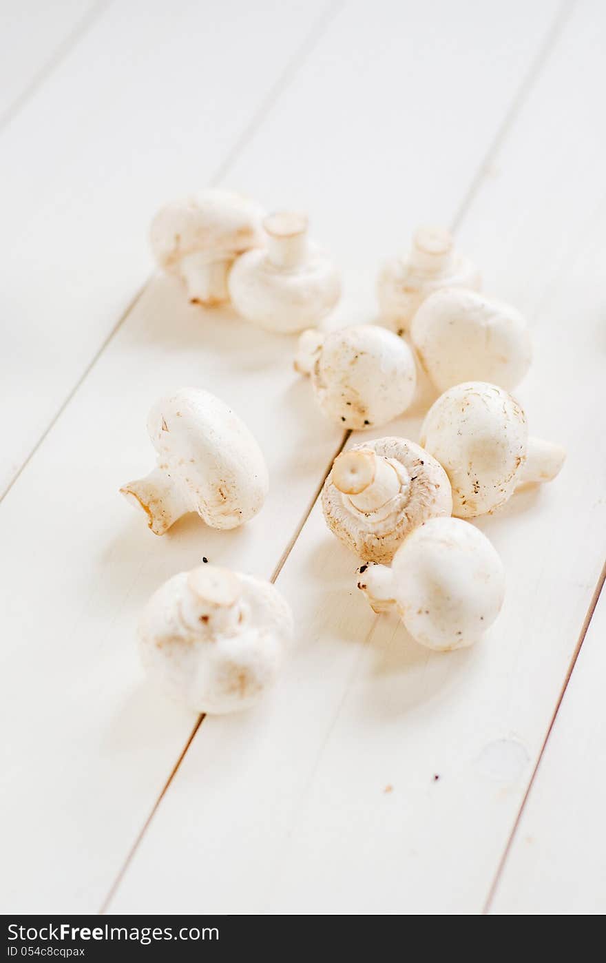 Fresh white champignon mushrooms on a wooden table. Fresh white champignon mushrooms on a wooden table