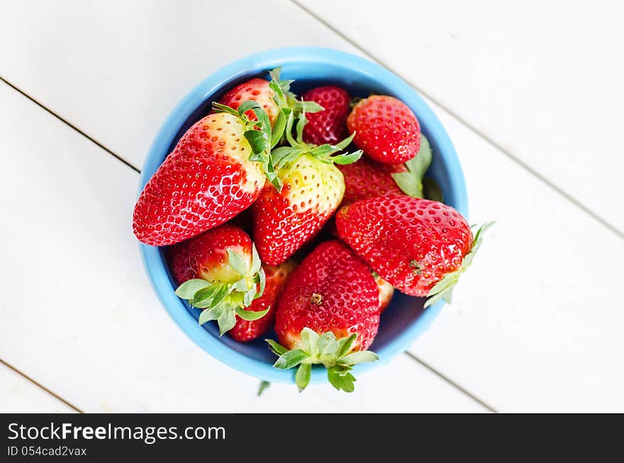 Big red strawberries in a blue pot