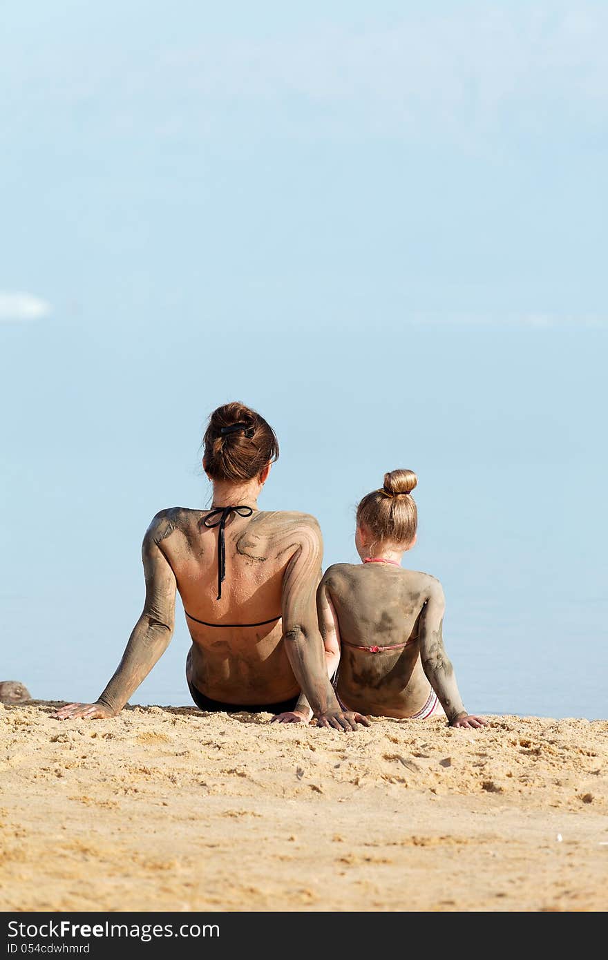 Mother and daughter resting in a bikini by the sea