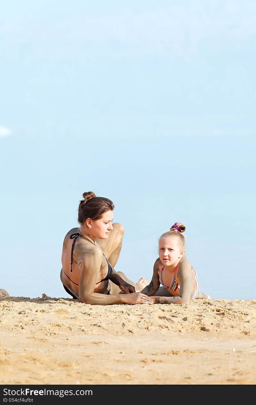 Girl resting on the bank of the sea mud body treatment