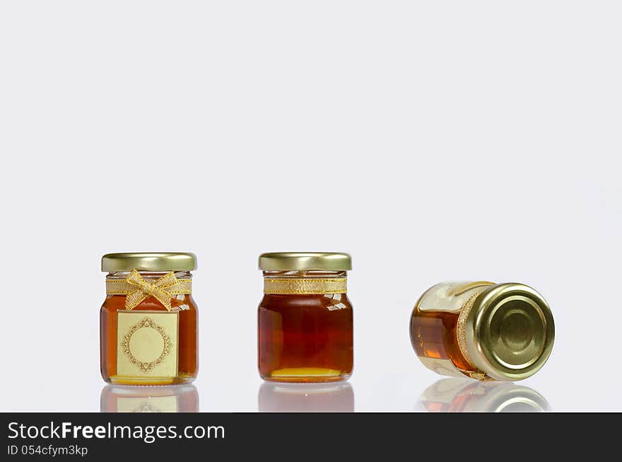 Honey in the bottle on white background