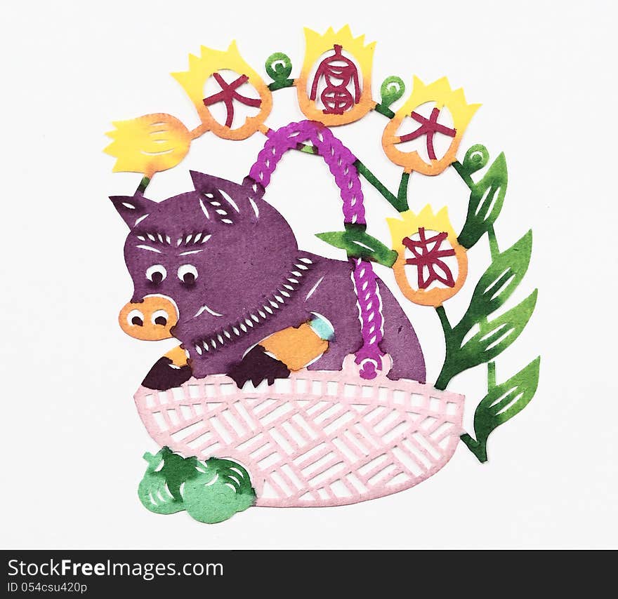 Paper-cut of a pig in a basket together with four Chinese characters “Da Fu Da Gui” which mean “riches and honour”.