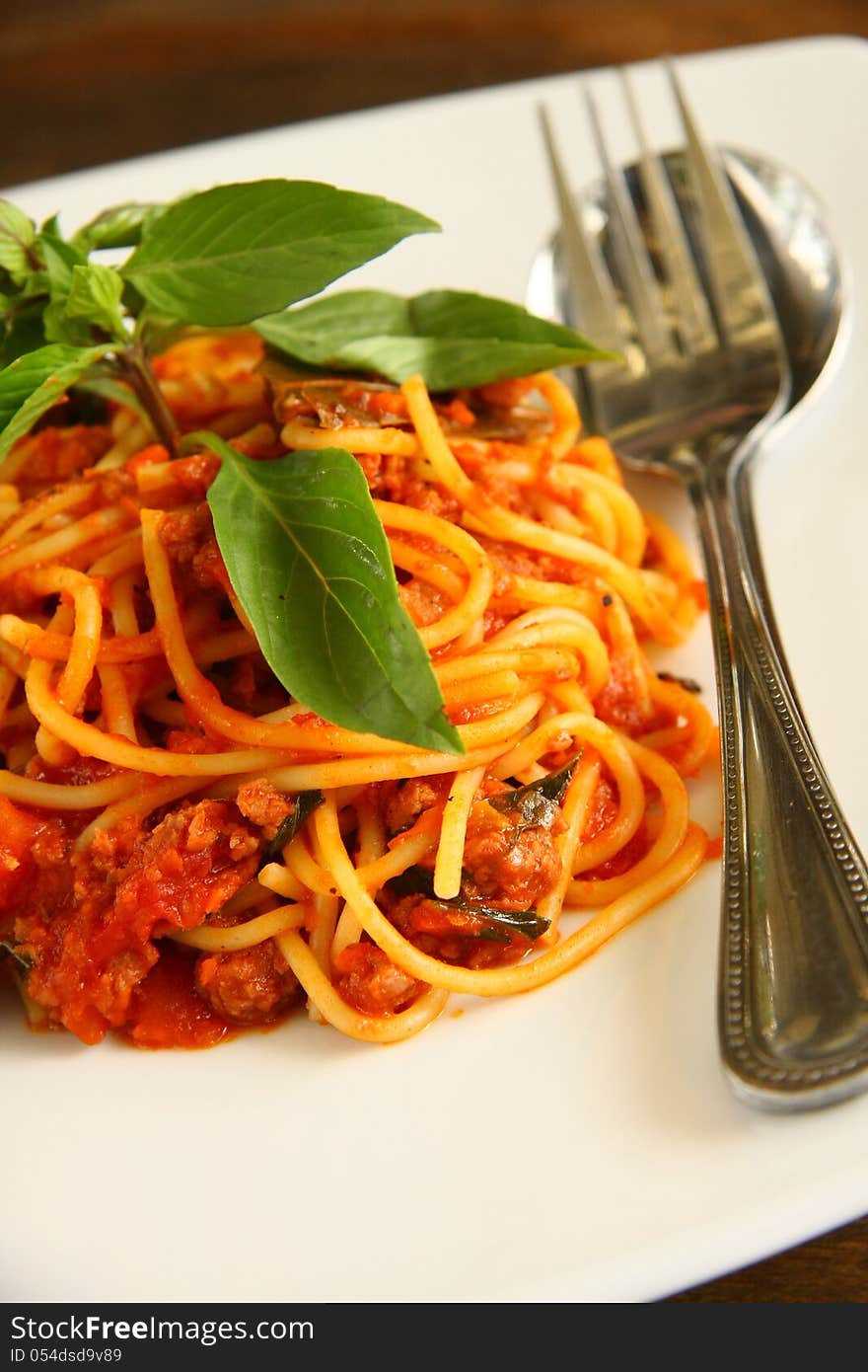 Spaghetti with Thai style sauce and fresh basil on top.